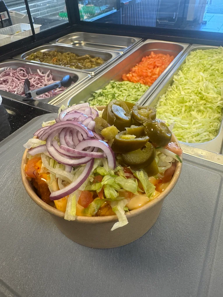Verse kapsalon met krokante kip, jalapeños en rode ui